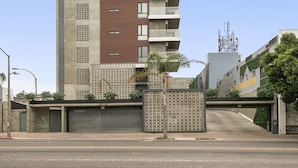 A tall, modern building with multiple balconies and a mix of brick and concrete facades.