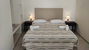 Ein Hotelzimmer mit einem Bett, zwei Nachttischen mit Lampen, einer Kopfteil und einer Deckenleuchte.