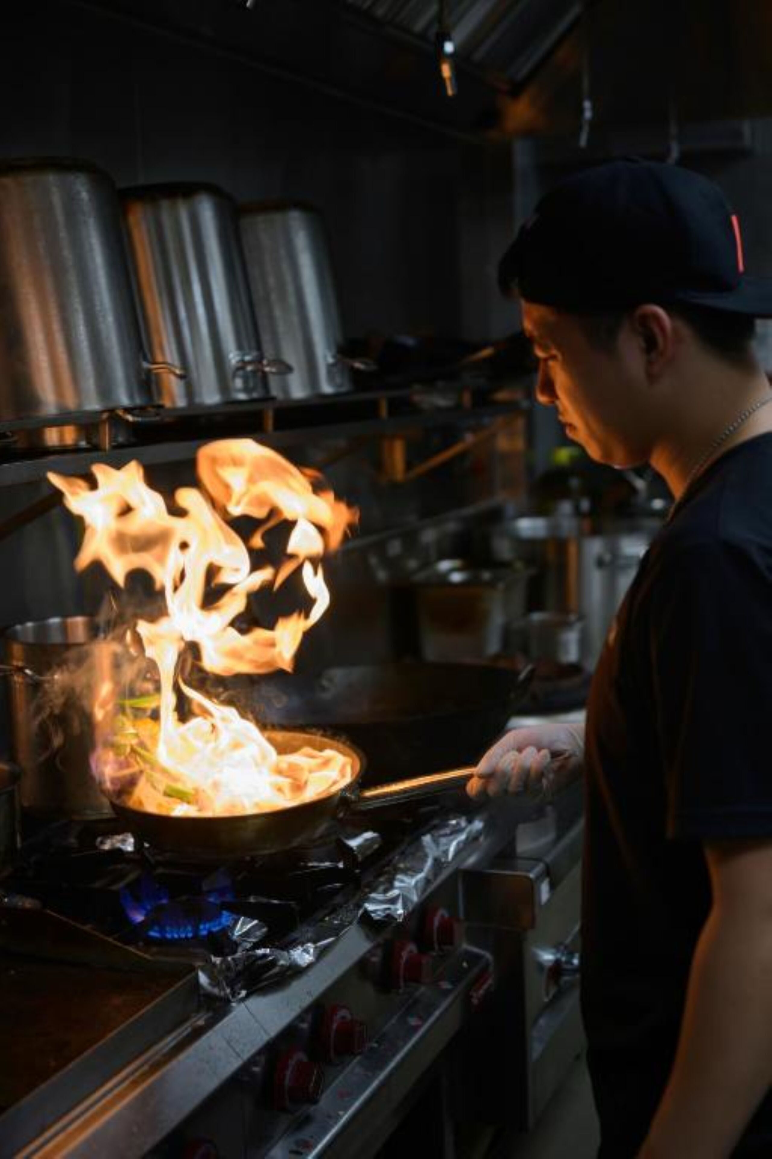 Un chef cocina sobre llamas en una estufa en una cocina.