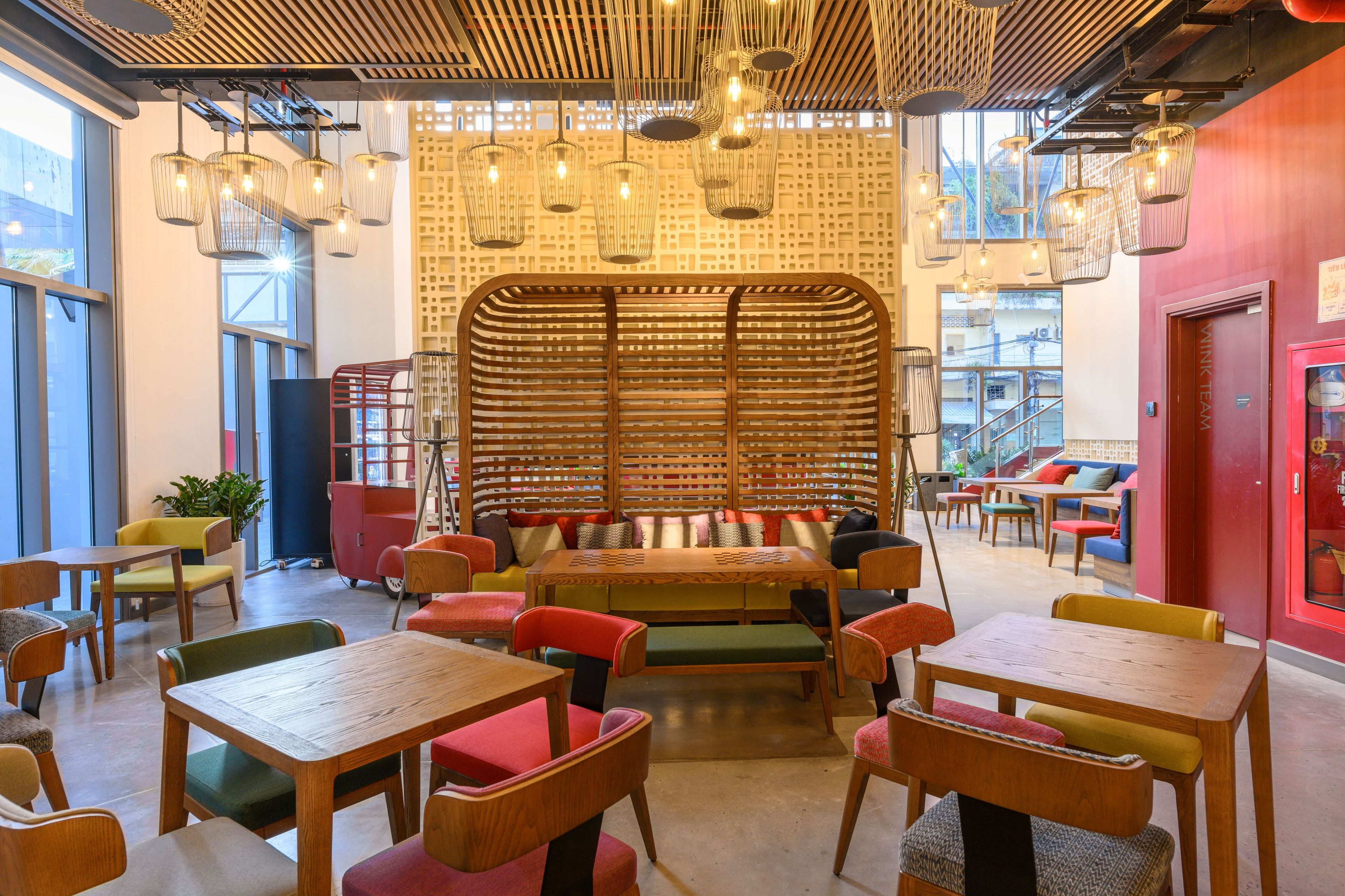 A modern interior with wooden furniture, a central seating area, and hanging pendant lights.