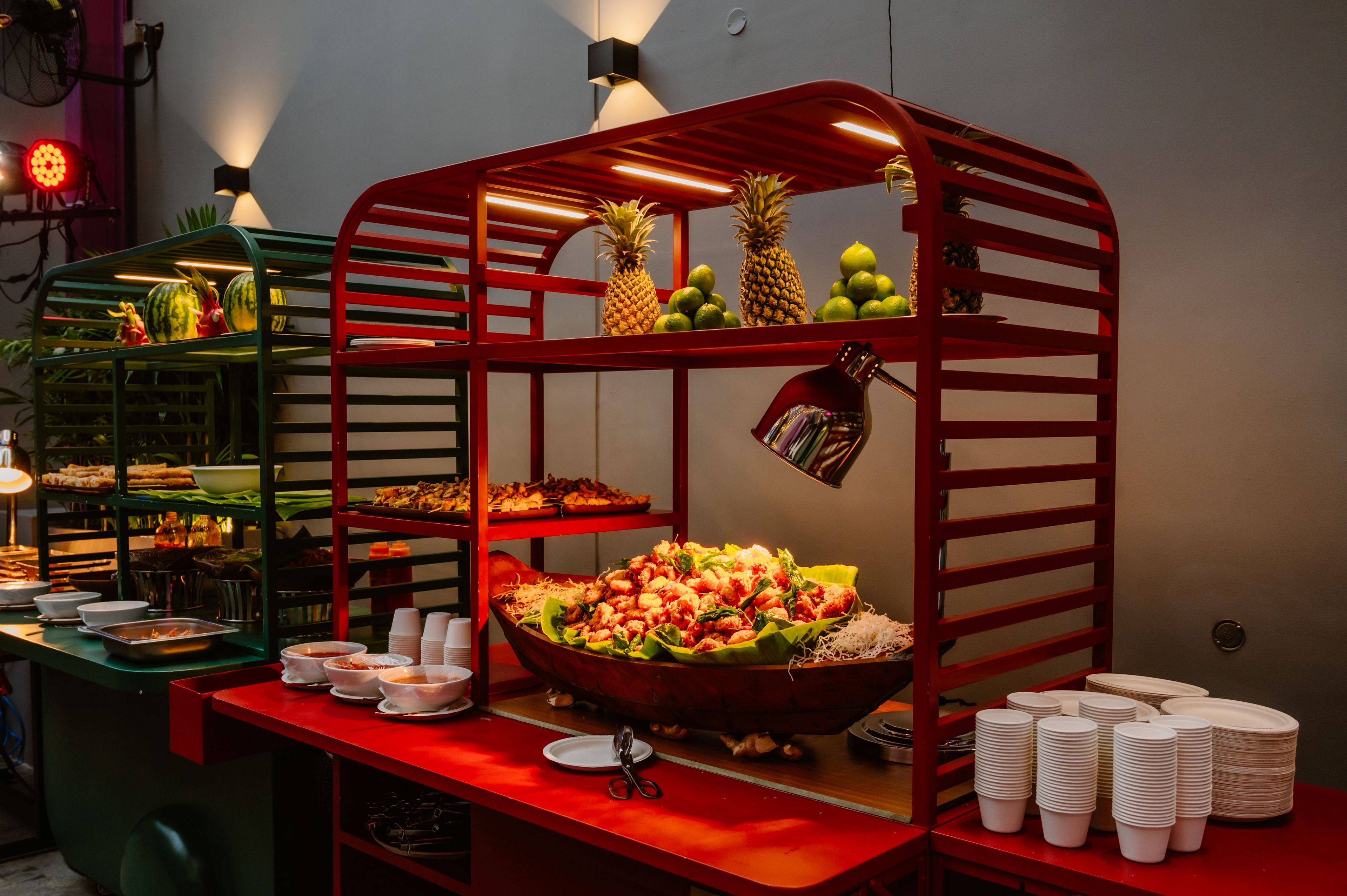 A buffet setup with a variety of food items and a red-framed serving station.