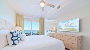 A hotel room with a bed, a TV, a dresser, and a view of the ocean. - Silver Beach 602 |  Updated, Direct Beach Front, Pet Friendly! (Orange Beach)