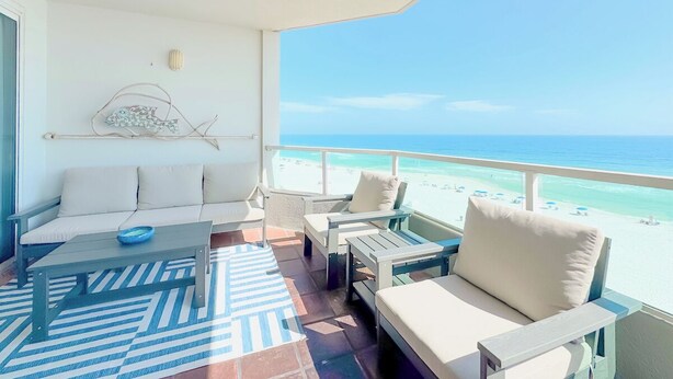 A balcony with a sofa, chairs, and a table. - Silver Beach 602 |  Updated, Direct Beach Front, Pet Friendly! (Orange Beach)