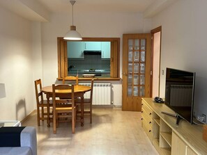 Cozy living space with a kitchenette, dining table, and TV.