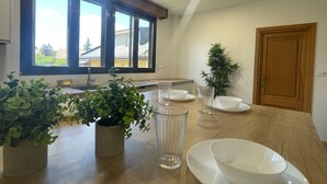 Una cocina moderna con encimera de madera, un ventanal grande y una planta en maceta.