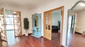 Amplia habitación con piso de madera, un espejo grande y un armario azul con espejo.