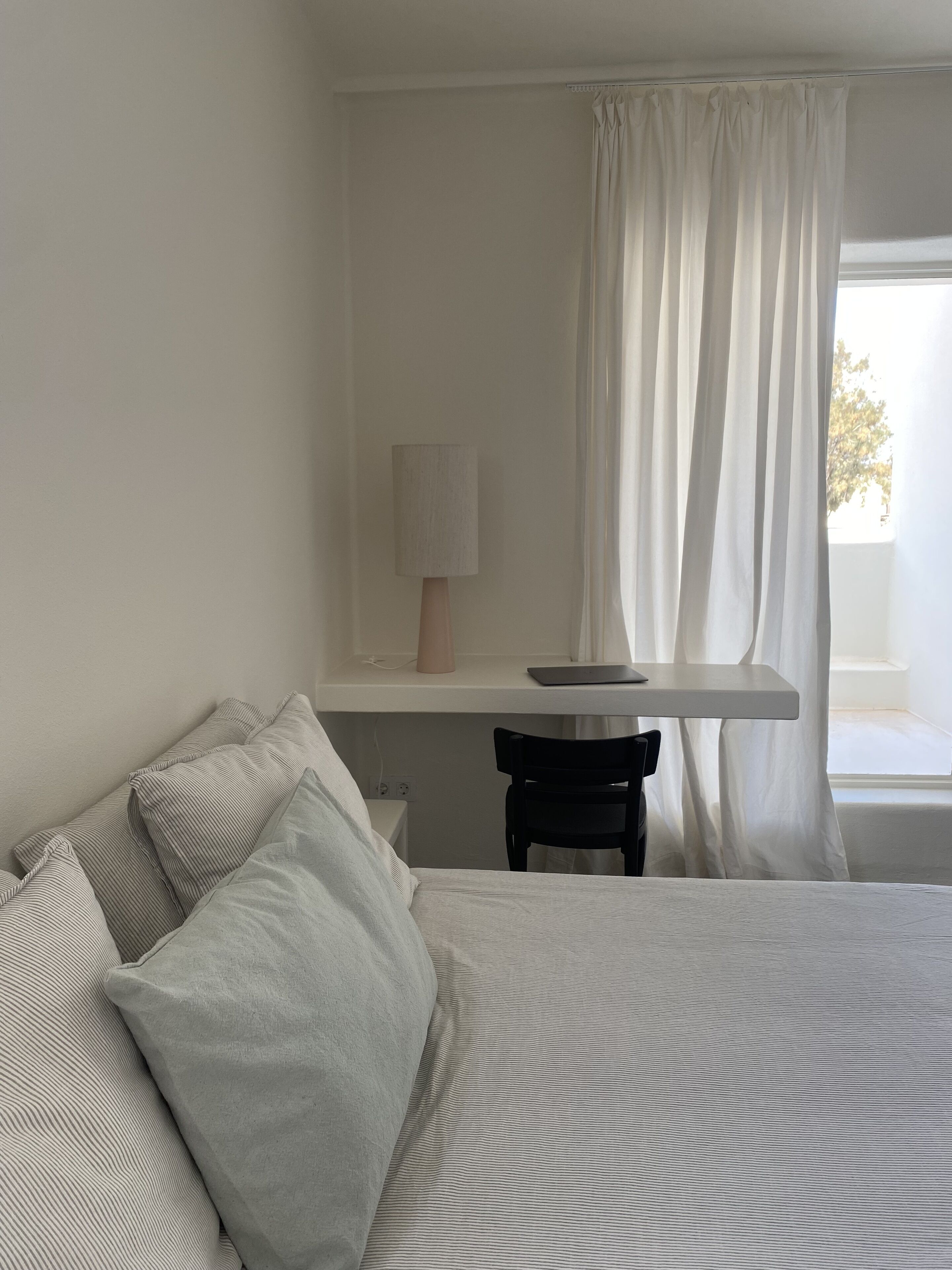 Ein Schlafzimmer mit Bett, Schreibtisch, Stuhl und Lampe.