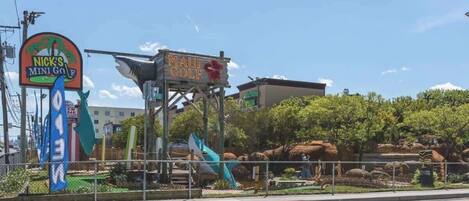 A sign for Nick's Mini Golf and Maui Golf.