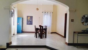 Un coin repas avec une table et des chaises, un buffet bleu et un tableau accroché au mur.