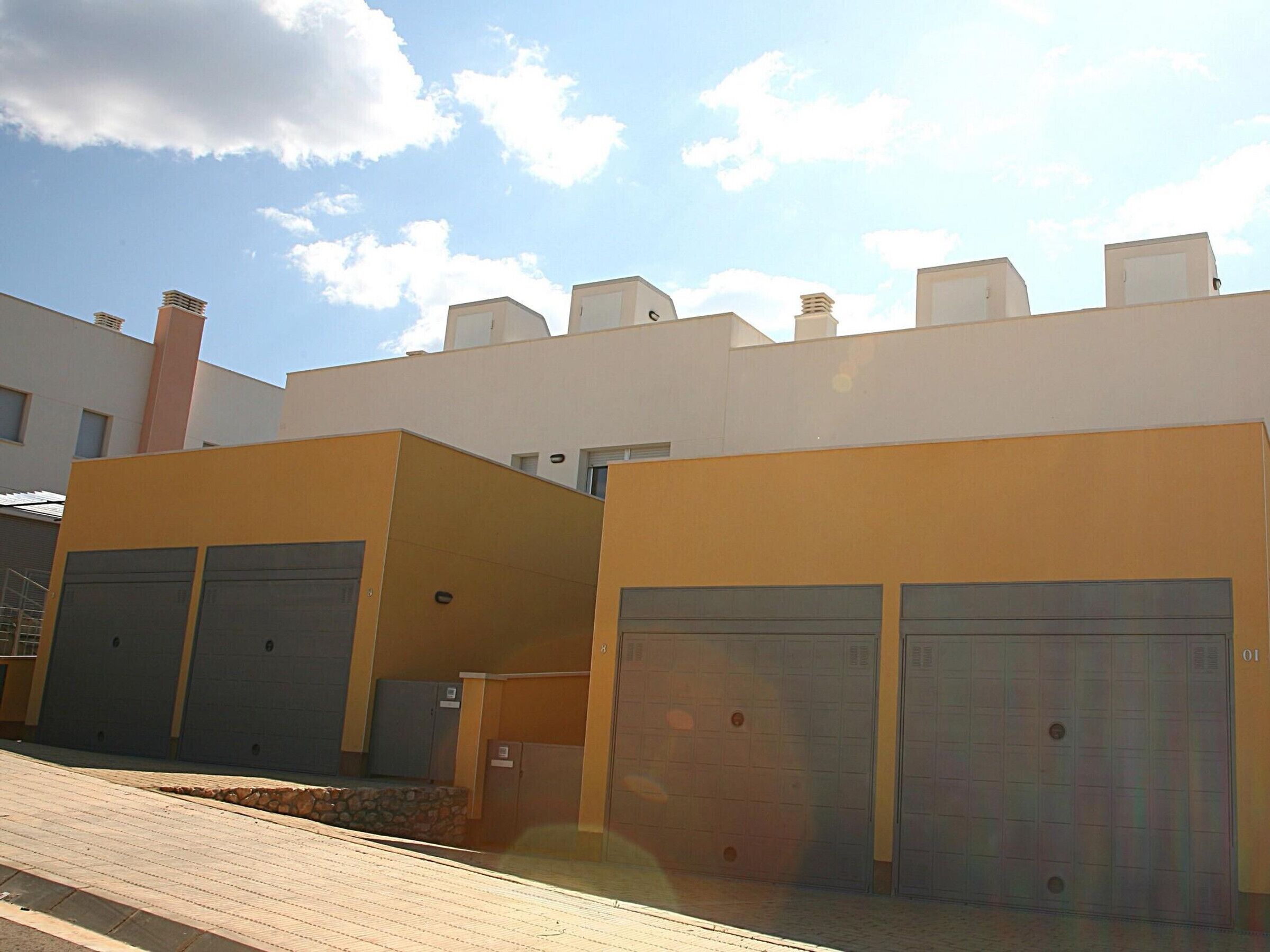 A modern building with two garage doors and a paved entrance area.