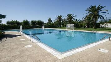 Ein rechteckiger Swimmingpool mit weißem Sonnendeck und Metallhandläufen.