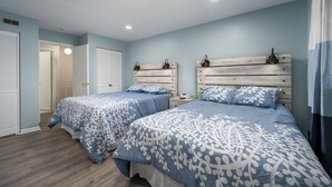 A bedroom with two beds, wooden headboards, and a light blue wall. - New Listing!  Updated 1 bedroom bayside with a pool! (Ocean City)