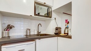 A modern kitchen with a built-in microwave, stainless steel sink, and a coffee maker. - 229 Suite Fantasyland - Superb apartment (Paris 02 Bourse)