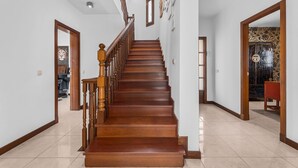 Un escalier en bois, doté d’une rampe, menant à un palier.