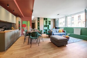 Um espaço de estar moderno com área de jantar, cozinha e espaço para sentar.