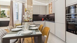Une cuisine moderne avec des armoires blanches, un plan de travail noir et un four encastré.