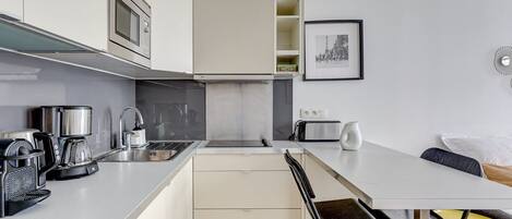 Microondas, lavavajillas, cafetera o tetera y mesa de comedor