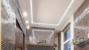 Une cuisine moderne équipée d’un four encastré, d’un four à micro-ondes et d’une fenêtre située au-dessus de l’évier.
