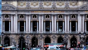 Un bâtiment historique à l’architecture classique, doté d’une entrée centrale ornée de colonnes et d’une grande porte en arc de cercle.