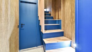 A blue door leading to a wooden staircase with a handrail. - 141 Suite Klein - Superb apartment in Paris. (Paris 03 Temple)