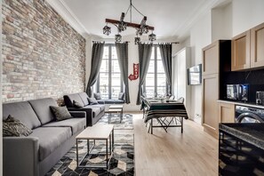Una sala de estar moderna con sofá, mesa de comedor y zona de cocina.