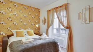 A bedroom with a bed, two pillows, a bedside table, a lamp, and a window with curtains. - 246 Suite Naples Superb apartment in Paris (Paris 17 Batignolles-Monceau)