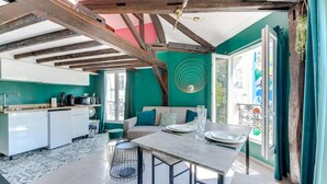 Eine moderne Küche mit weißen Schränken, eine Essecke mit Tisch und Stühlen sowie ein Balkon mit Blick.