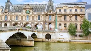 A historic building with a prominent clock tower and a bridge over a river. - 348 Ponthieu - Superb apartment in Paris (Paris 08 Élysée)