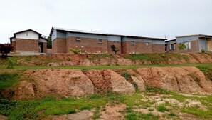 Un edificio de dos pisos con techo plano y paredes de ladrillo.