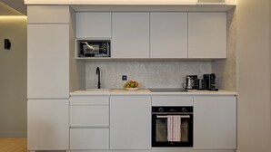 A modern kitchen with a built-in microwave, coffee maker, and oven. - 365 Suite Fondary 4 - Superb apartment in Paris (Paris 15 Vaugirard)