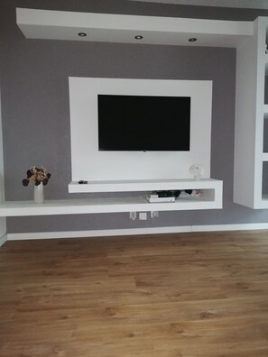 Relax in this stylish living room with a large flat-screen TV and entertainment unit.