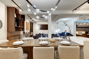 Enjoy meals in this stylish dining area with a sofa, TV, and ample lighting.