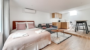 A modern apartment with a large bed, a sofa, a dining area, and a kitchen. - 136 Suite Harold - Superb apartment in Paris. (Paris 02 Bourse)
