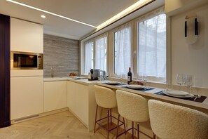 Een koelkast, een magnetron, een koffiezetapparaat/waterkoker, eettafels