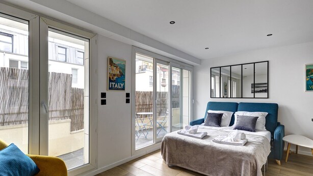 A modern bedroom with a large bed, a blue headboard, and a view of the outside. - 320 Dolce Vita Suite - Superb apartment (Suresnes)
