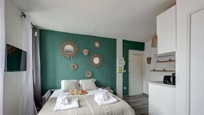 Ein Schlafzimmer mit einem Bett, Nachttischen, einem Kleiderschrank und einer Küchenzeile.