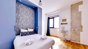 A modern hotel room with a large bed, a wooden floor, a marble-patterned headboard, and a window with curtains. - 113 Suite Lui - Sumptuous apartment in Paris (Paris)
