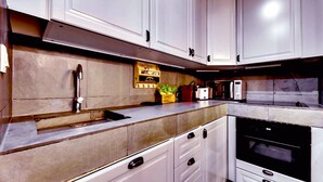 A modern kitchen with white cabinets, a stainless steel sink, a microwave, and an oven. - 113 Suite Lui - Sumptuous apartment in Paris (Paris)