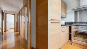 A modern kitchen with wooden cabinets, stainless steel appliances, and a visible oven. - The Acton Collect (London)