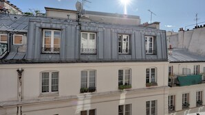 A multi-story building with a grey facade, multiple windows, and balconies. - 630 Suite Yoake - Superb apartment in Paris (Paris 01 Louvre)