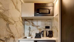 A compact kitchen with a built-in microwave, a coffee maker, and a small refrigerator. - 366 Suite Legendre - Superb apartment in Paris (Paris 17 Batignolles-Monceau)