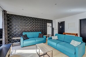 Relax in this stylish living room with two sofas, a coffee table, and a geometric-patterned wall.