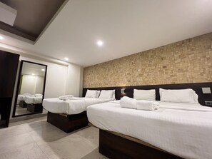 Una habitación de hotel moderna con dos camas, un espejo grande y una pared con textura.