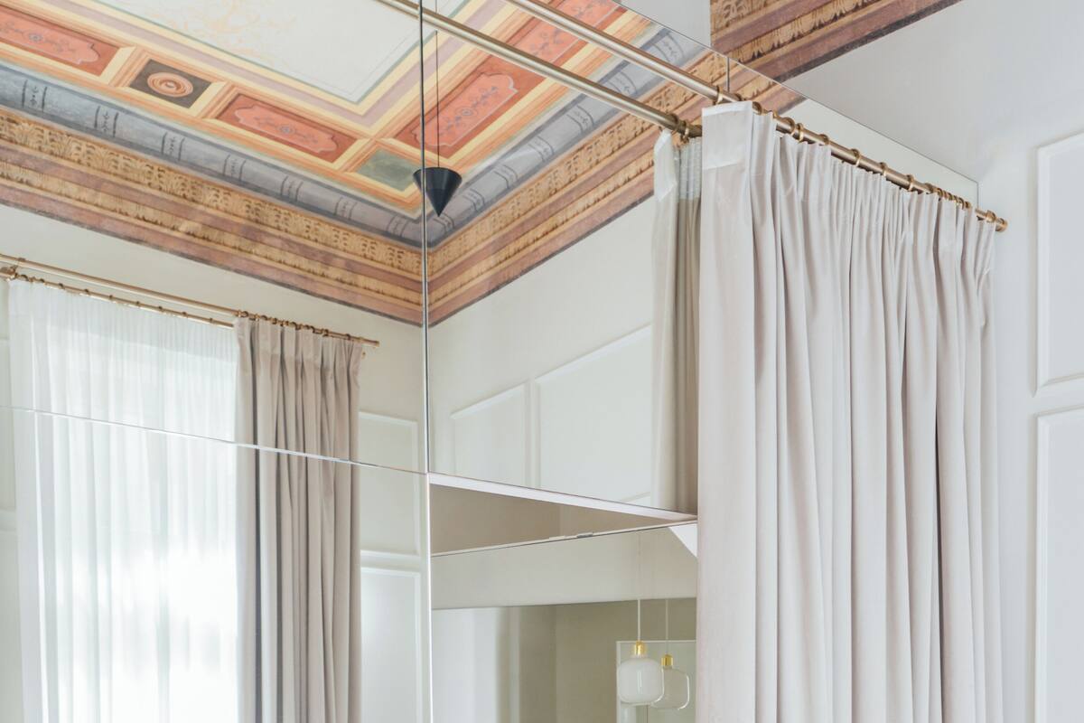 Un dormitorio moderno con una cama grande, un tocador con espejo y un techo con diseño decorativo.