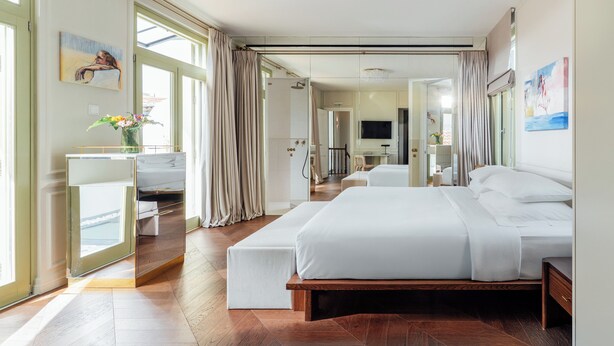 Habitación de hotel moderna con una cama grande, un escritorio y vistas a la ciudad.