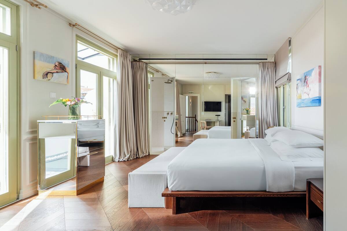 Habitación de hotel moderna con una cama grande, un escritorio y vistas a la ciudad.