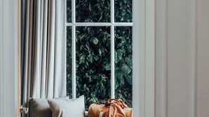 Una habitación con ventana, un banco y una puerta.