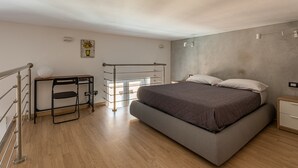 Une chambre à coucher avec un lit, un bureau, une chaise et une petite table.