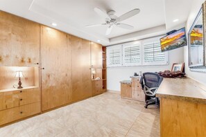 Une cuisine moderne avec des meubles en bois, un bureau intégré et un ventilateur de plafond.