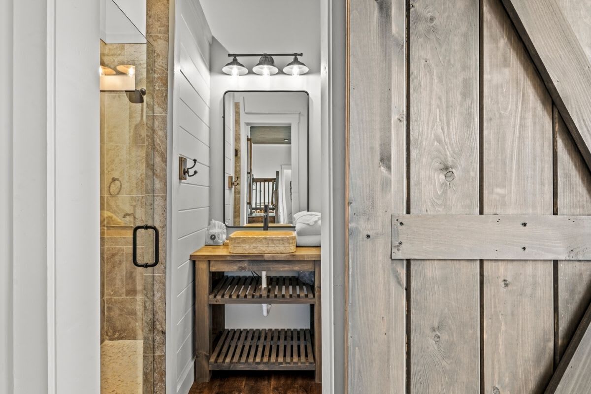 A bathroom with a wooden vanity, a mirror, and a towel rack.